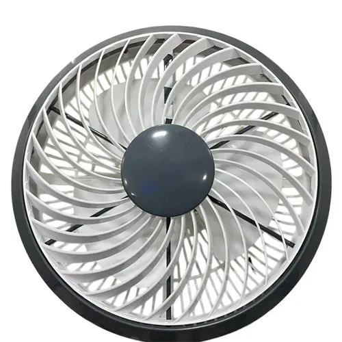 A front-view product photo of a round, compact cabin fan. The fan features a black outer rim and an innovative white inner grille with a spiral blade design, which is designed to rotate and distribute air in a circular pattern. The center is dark gray. This type of fan is ideal for small, enclosed spaces such as vehicle, boat, or truck cabins.