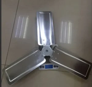 A lightweight and durable stamped aluminum fan propeller designed for industrial cooling applications. This 3-blade unit is constructed from pressed aluminum sheets riveted to a central hub, offering a perfect balance of strength and aerodynamic efficiency. As shown on the scale, it weighs approximately 650g, making it ideal for high-speed wall or pedestal fans.